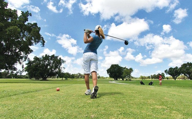 Golfer taking a swing at the red tees of the golf course